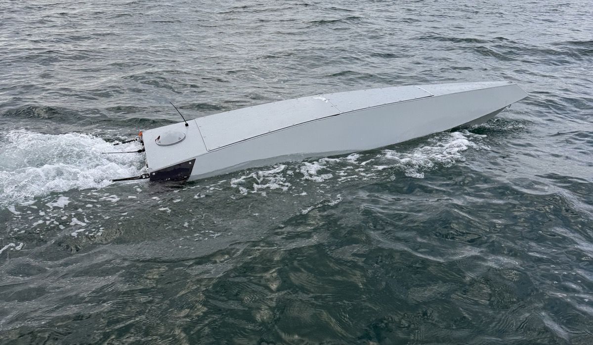 The two and a half metre hull seen from abeam, low in the water, drive at the transom.