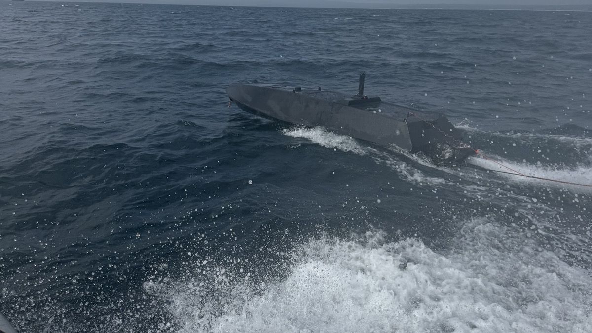 The six metre hull under way with its communications mast stepped amidships.